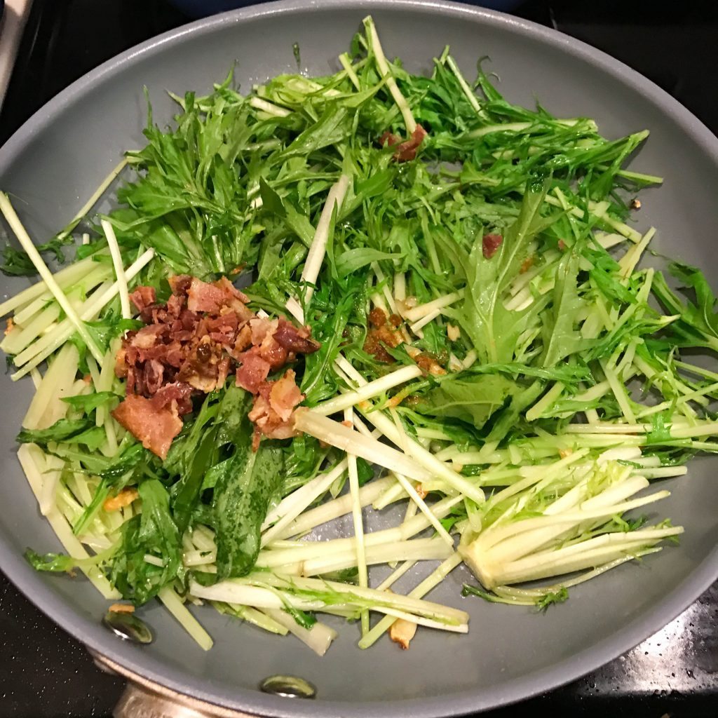 Mizuna with mustard greens bacon and garlic on a pan