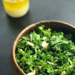 kale salad with lemon dressing topped with almonds