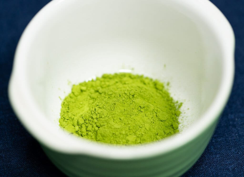 matcha green tea powder in a white cup