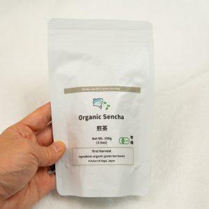 organic sencha japanese tea in hand white background