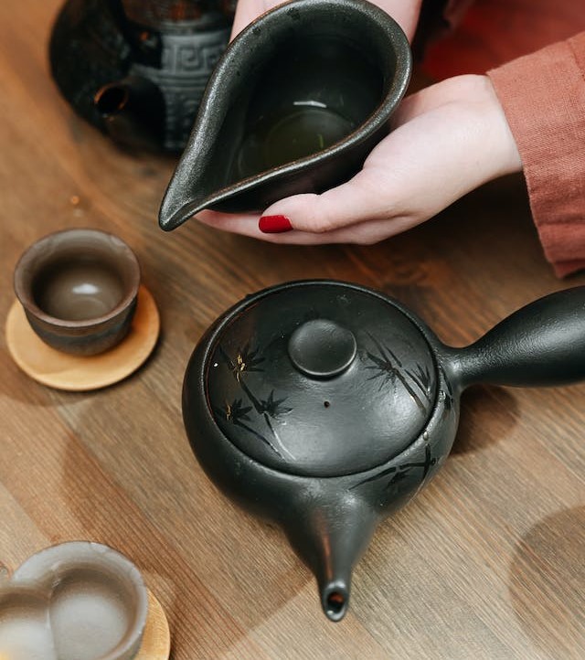 hand pouring tea and Yokode Kyusu on the table