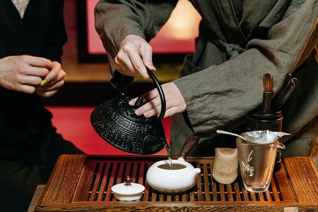 a person pouring hot water into a tea pot