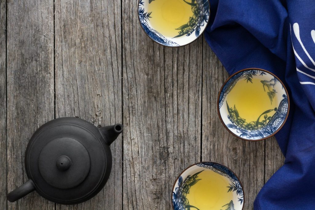 A Japanese teapot and a cup of tea on a wooden table.