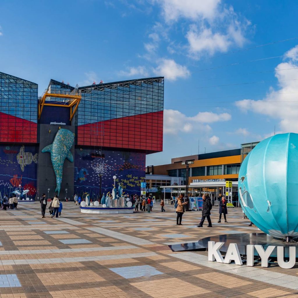A large blue ball in the middle of a plaza.