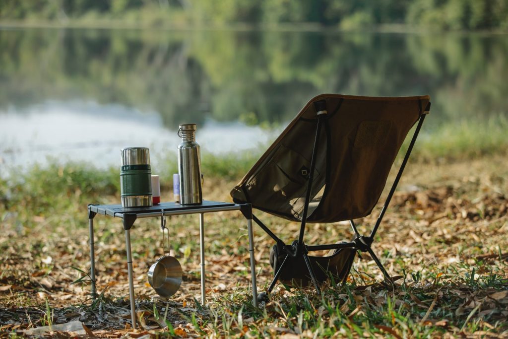 A camping chair equipped with a water cup and water bottle.