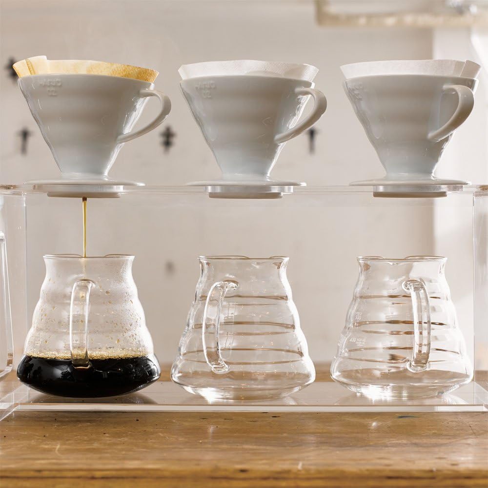 A set of coffee cups on a wooden table, comparing Hario V60 and Chemex.