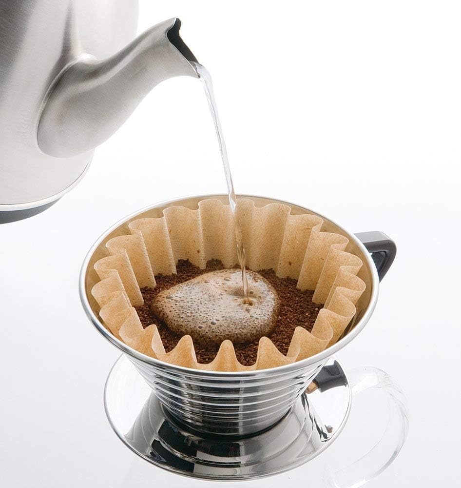A Hario V60 coffee dripper is being filled with coffee.