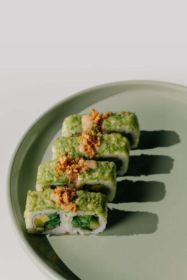A plate of green sushi with wasabi on a white background.