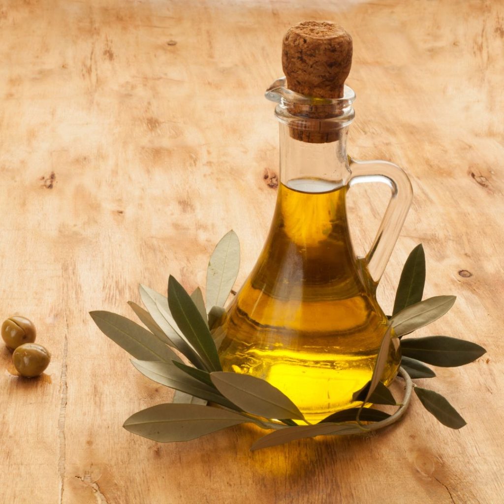 A bottle of extra virgin olive oil rests on a wooden table.