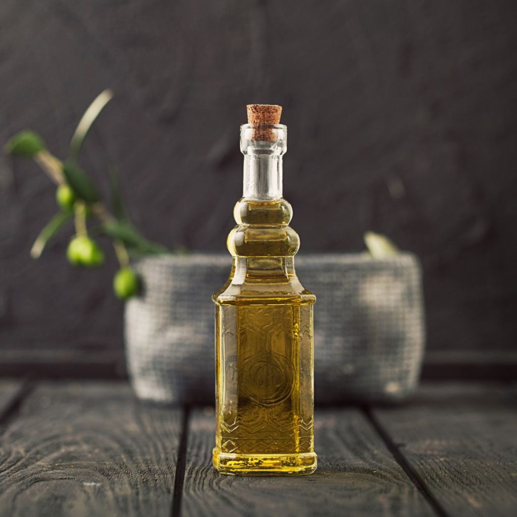 1 - A bottle of extra virgin olive oil rests on a wooden table