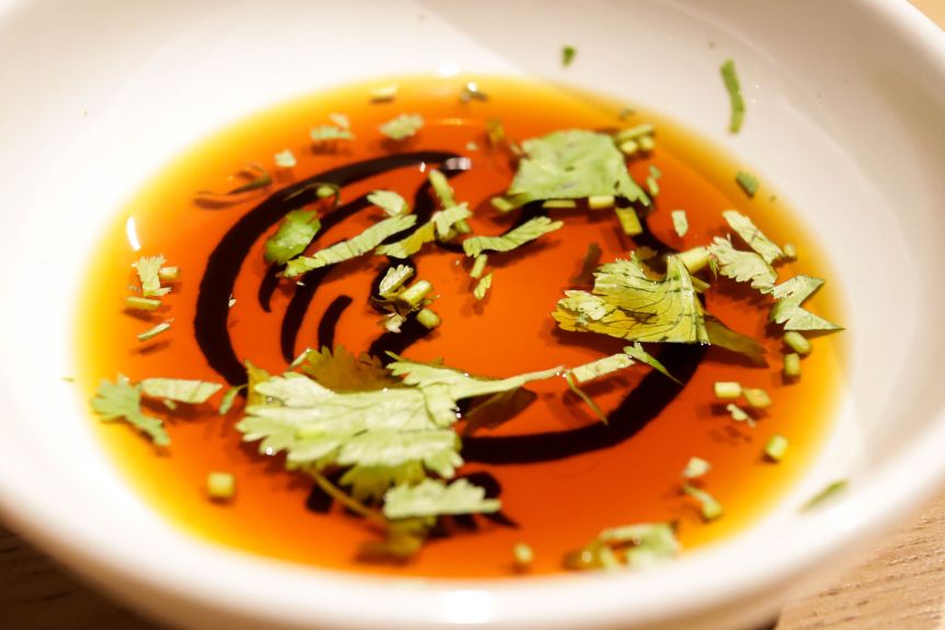Japanese ponzu sauce with coriander in a dipping bowl