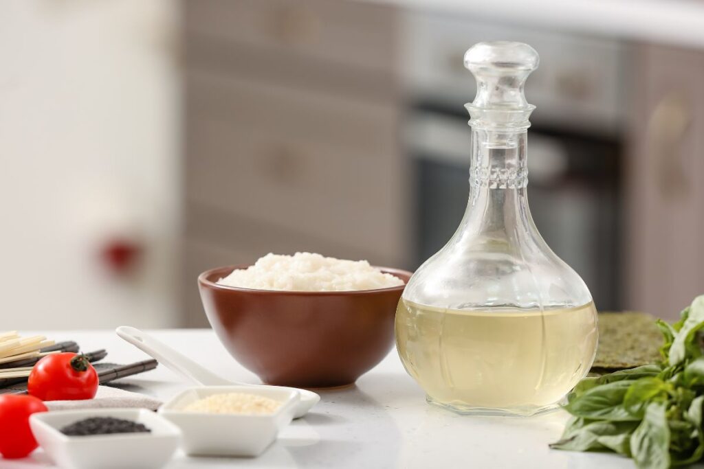 a rice vinegar in a bottle beside a bowl of rice in a kitchen countertop